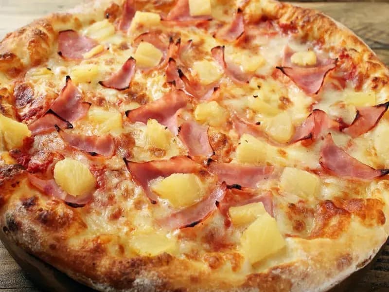 Pizza HawaianaPizza hawaiana con piña, jamón y queso mozzarella.